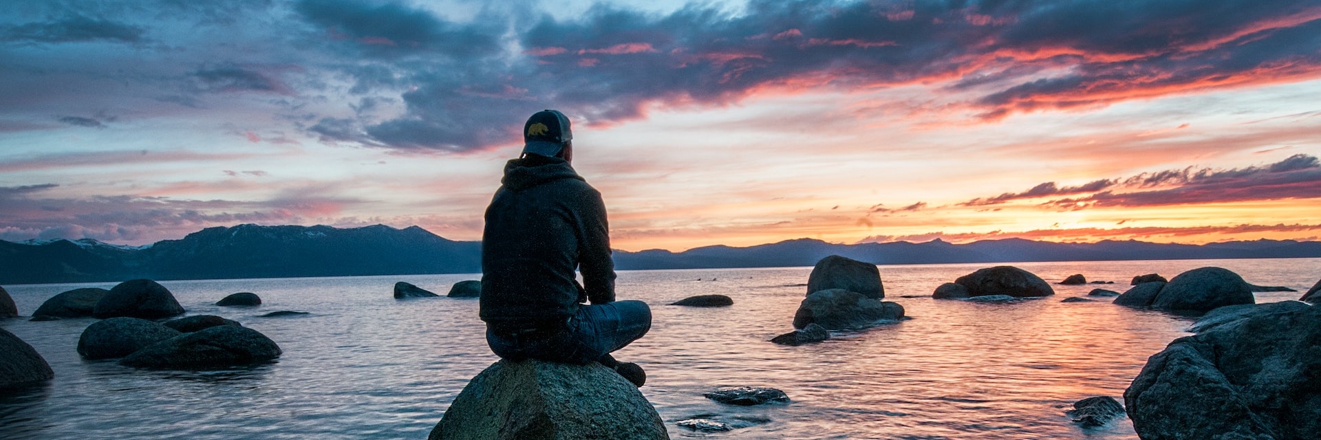 Man sitting on a stone in the lake